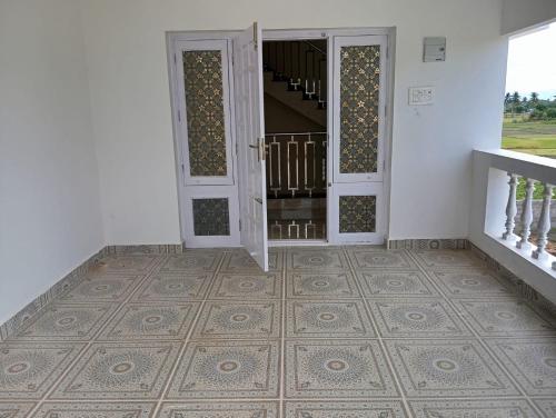 an empty room with a door and a staircase at Malliga Farm House in Turinjāpuram