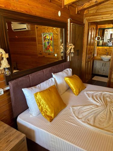 a bedroom with a bed with yellow pillows at Adrasan blue bay hotel in Kumluca