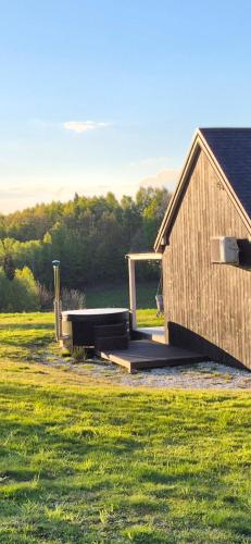 a wooden building in the middle of a field at Chatka ChoćCo in Ryglice