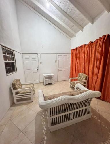 a living room with a bed and chairs in it at Pondbottom Apartments Hotel in Saint James