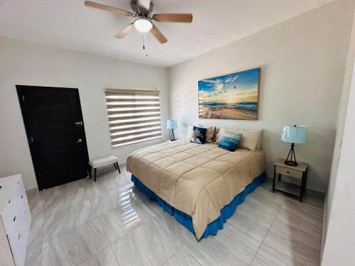 a bedroom with a bed and a ceiling fan at Rocky point beach house. in Puerto Peñasco
