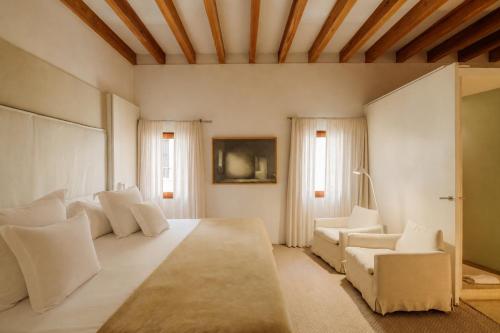a large living room with white furniture and windows at Convent de la Missio - Grand Luxury Boutique hotel, Adults Only in Palma de Mallorca