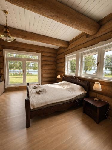 a bedroom with a bed in a room with wooden walls at Private lakeside holiday house with fireplace, sauna, hot tub - Ezernams Dzintars in Valdemārpils
