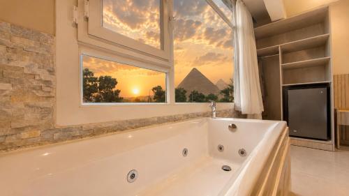 a bath tub in a bathroom with a window at Dar Pyramids Boutique in Cairo