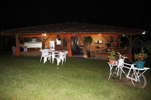 a table and chairs in front of a gazebo at night at Finca Hotel Cabaña Fercho in Quimbaya