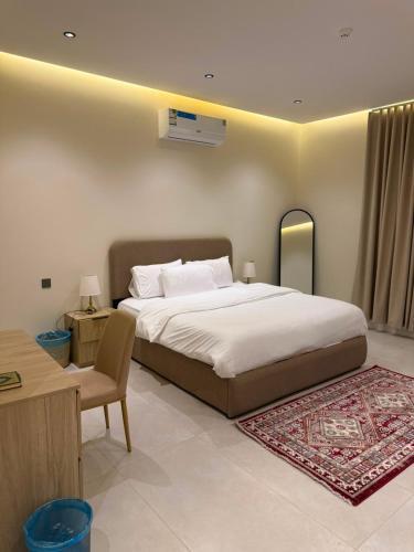 a bedroom with a large bed and a chair at بالم هيلز Palm Hills in Baljurashi