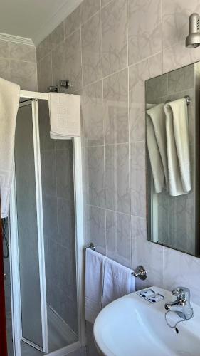 a bathroom with a sink and a shower and a mirror at Pension As Termas in Bubaces