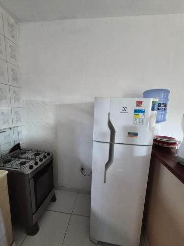 a white refrigerator in a kitchen with a stove at Nataliana's House in Cabo Frio