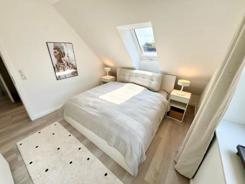 a bedroom with a bed and two night stands at Vollmöblierte hochwertige neue Apartments in Klevendeich