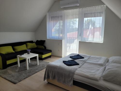 a bedroom with a bed and a couch and a table at Villa Balifornia in Balatonboglár