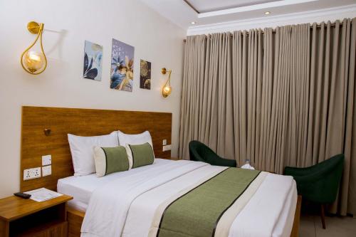 a hotel room with a bed and a desk and curtains at Velvet Suites in Kigali