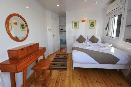 a bedroom with a bed and a mirror and a piano at Three pyramids Dahabiya in Esna