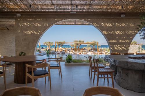 a restaurant with tables and chairs and a view of the ocean at Glaronissi Beach in Plaka