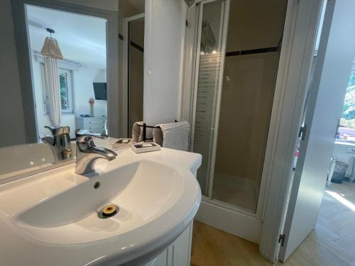 a white bathroom with a sink and a shower at Gîtes chez julie in Beaucamps-Ligny