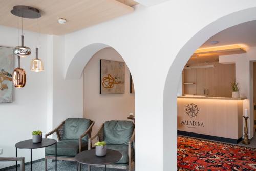 a room with chairs and tables and a counter at Aparthotel Saladina in Gaschurn