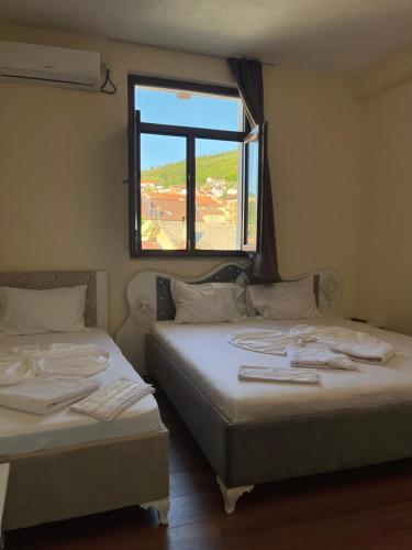 two beds in a room with a window at Center Side in Prizren