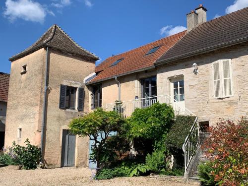 an old stone house with a staircase in a yard at La Parenthèse Bourguignonne in Savigny-lès-Beaune