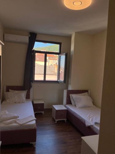 a room with two beds and a window at Center Side in Prizren