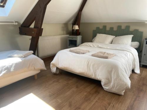 a bedroom with two beds with white sheets at Gîtes chez julie in Beaucamps-Ligny