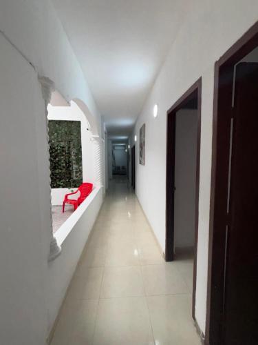 a hallway with a red bench in a white room at Hotel Montserrat in Valledupar
