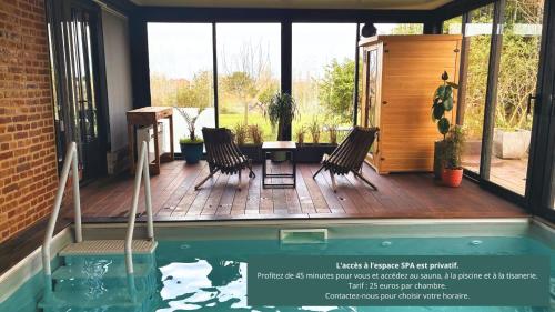 a house with a swimming pool and two chairs at Entre Terre et Estuaire & Spa in La Rivière Saint Sauveur