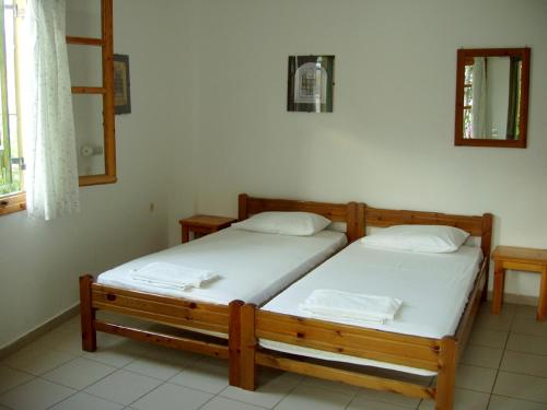 2 camas individuales en una habitación con ventana en CretanHouse en Myrtos