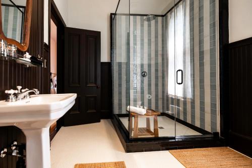 a bathroom with a sink and a glass shower at The Truitt in Saint Louis