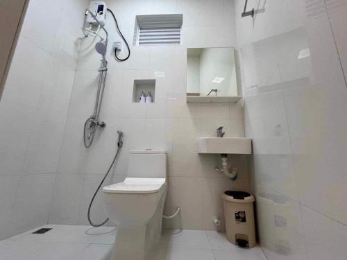 a white bathroom with a shower and a toilet at White Water Inn in Muli