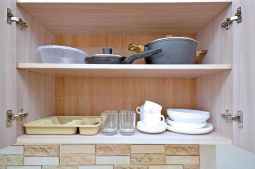 ein Schrank mit Geschirr und Besteck darin in der Unterkunft ОРЕЛ in Yerevan
