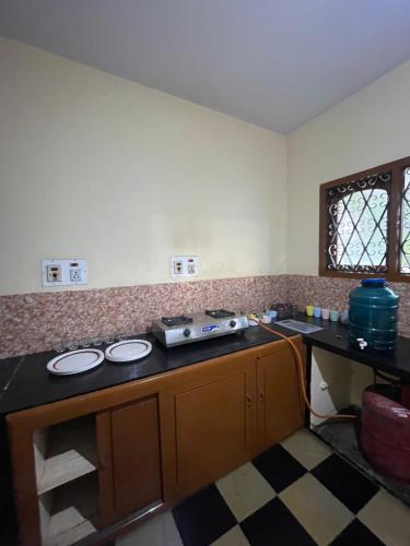 a kitchen with a stove and a counter top at Oakville in Mysore