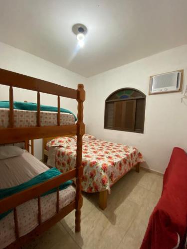 a bedroom with two bunk beds and a window at Nataliana's House in Cabo Frio