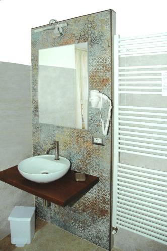 a bathroom with a sink and a mirror at B&B La Loggia e L’Orologio in Castiglione del Lago