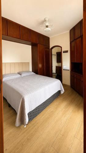 a bedroom with a large bed with a wooden headboard at Flat em Hotel com Estacionamento Grátis e Piscina in Santos
