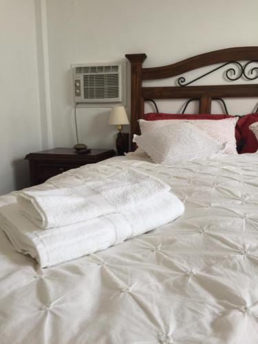 a white bed with two white pillows on it at Best place in Plaza Mayor Lima, Pizarro building in Lima