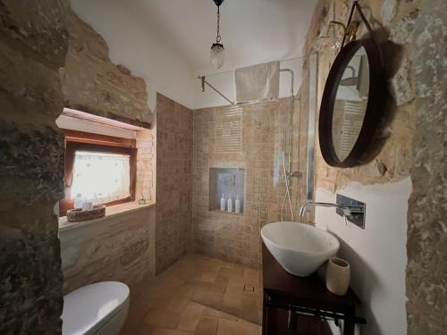 a bathroom with a sink and a toilet and a mirror at Casa del boscaiolo in Trevi