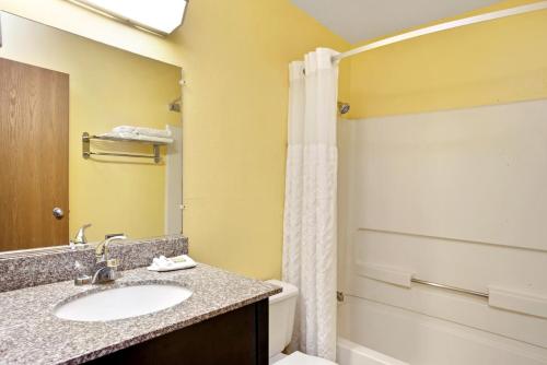 W łazience znajduje się umywalka, toaleta i prysznic. w obiekcie Super 8 by Wyndham Romeoville Bolingbrook w mieście Romeoville