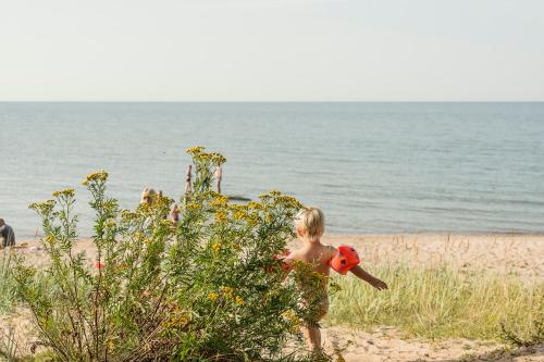 a little girl walking on the beach with a toy at Adami Country Guesthouse in Vainupea