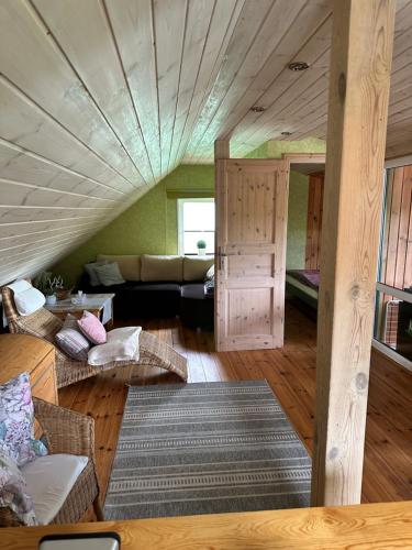 a living room with a couch and a room with a ceiling at Domek wypoczynkowy Nad Brdą in Przechlewo
