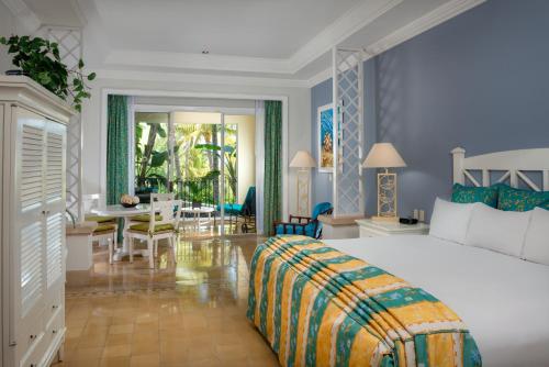 a bedroom with a large bed and a dining room at Pueblo Bonito Emerald Bay Resort & Spa - All Inclusive in Mazatlán