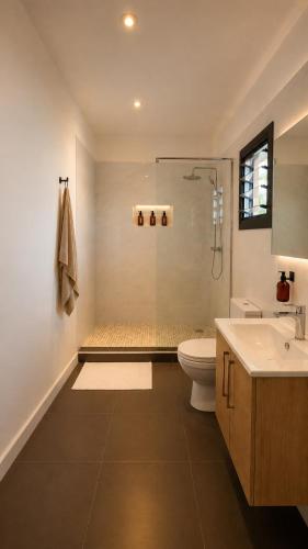 a bathroom with a shower and a toilet and a sink at Teranga Tides in Bijilo