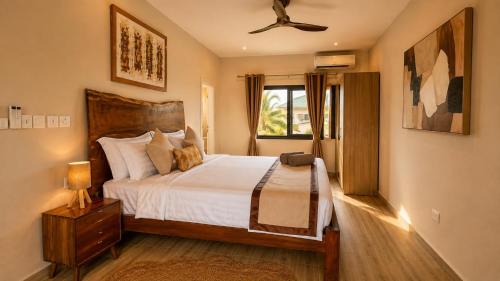a bedroom with a large bed and a window at Teranga Tides in Bijilo