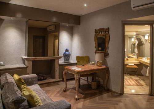 a living room with a table and a mirror at Quinta Real Guadalajara in Guadalajara