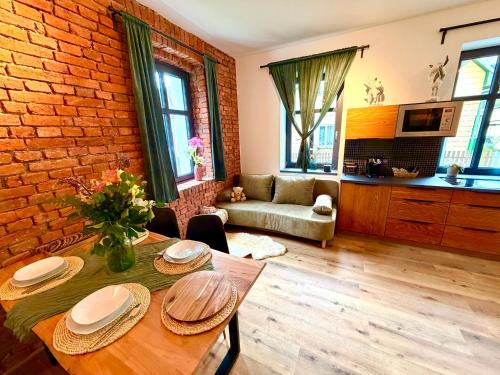 a living room with a table and a brick wall at Apartmány CHATTA in Horní Maršov