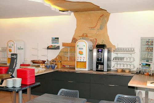 a kitchen with a counter with a coffee machine at Hotel Aquarius in Canet-en-Roussillon
