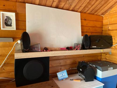 a room with a wooden wall with a tv and speakers at Naturunterkunft Leonberg in Leonberg