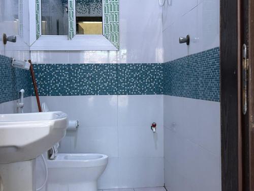 a bathroom with a toilet and a sink and a mirror at Aluruba Residence in Mogadishu