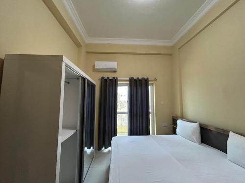 a bedroom with a bed and a window at Aluruba Residence in Mogadishu