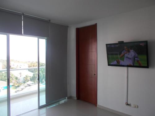 Una televisión o centro de entretenimiento en Costa Azul Suites Apartamento 603