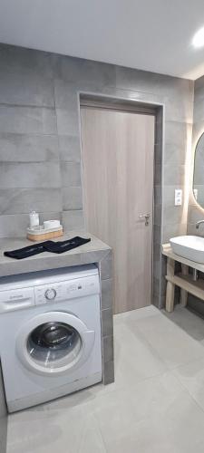 a washing machine in a bathroom with a sink at Alexandras Maisonette in Skiathos