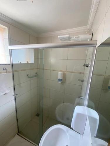 a bathroom with a glass shower and a toilet at Dom Hotel in Maringá